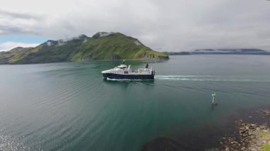 Alaska 'daki Unalaska adasının dağlarına doğru yelken açan bir balıkçı teknesi. Hollanda Limanı, Alaska ticari balıkçılık endüstrisinin merkezidir. Aleut adaları.