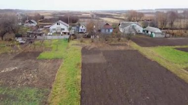 Bir İHA, Ukrayna 'daki çiftlik arazilerinin, köy evlerinin ve bahçelerin üzerinden uçuyor. Kırsal yaşam kavramı, doğayla iç içe. Sonbahar tarlaları. Doğu Avrupa 'nın köyleri.