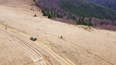 Dağlarda Offroad Turizmi. Turistler dağ zirveleri boyunca jiple geziyorlar. Sonbahar Karpatları Hava Manzarası. Göz kamaştırıcı dağ manzaraları. Kırılgan bir çevrede sayısız cip izi var..