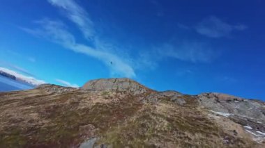 Parlak Gök 'te Karlı Dağların Üzerinde Çember çizen Kel Kartallar. Alaska, Unalaska 'dan İHA görüntüleri temiz kış havasında süzülen beyaz başlı kel kartalları gösteriyor. Hollanda Limanı, Aleutian Adaları.