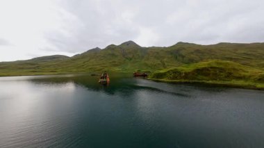 Unalaska adasının kıyı şeridi yakınlarındaki paslı batık gemilerin hava manzarası. Çevre kirliliği ve ekolojik felaket. Dünya okyanusunun kirliliği.