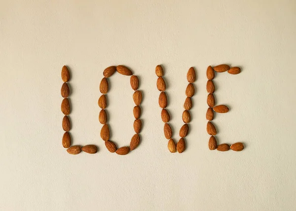 Açık bej arkaplanda badem fıstığı ile yazılmış 