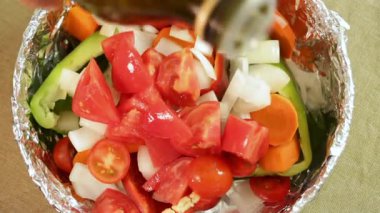 Ellerinizi masaya koyun ve zeytinyağı koyun. Fırın kabına taze doğranmış sebzeler koyun. Çan biberi, domates, soğan ve havuç doğal dokuları gösterir. Temiz yemek ve ev yapımı malzemeler kavramı.