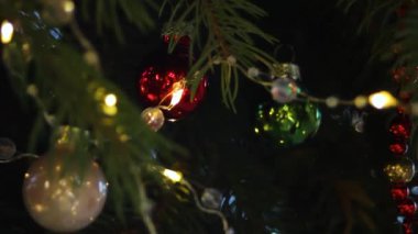 Cam ve peluş oyuncaklarla süslenmiş, parıldayan ışıklarla süslenmiş, gün batımında parıldayan bir Noel ağacı. Yüksek kaliteli FullHD görüntüler