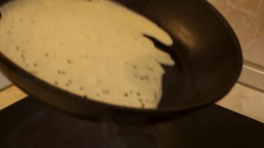Krep hamurunu ısıtılmış dökme demir tavaya kepçeyle dök. Evde krep pişirmek. - Evet. Yüksek kaliteli FullHD görüntüler