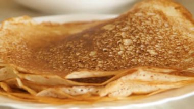 Altın krep diğer kreplerle birlikte bir tabağa konur. Krep pişirme kavramı. Yüksek kaliteli FullHD görüntüler