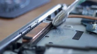 Laptopun soğutma radyatörünü yumuşak bir fırçayla temizliyorum. Dizüstü bilgisayar bakımı. Yüksek kaliteli FullHD görüntüler