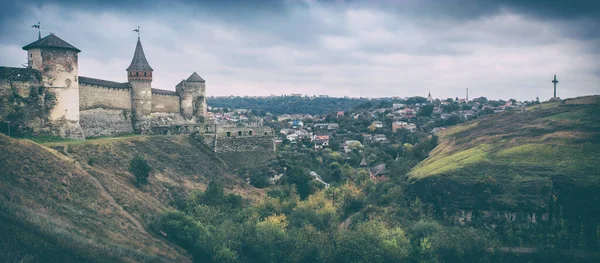 Fırtına bulutları tepedeki Orta Çağ Gotik kalesinin etrafında toplanırken çarpıcı bir ışık. Panoramik görünüm