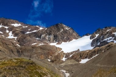 Ushuaia 'nın hemen dışındaki dağlar, Arjantin. Askeri buzullar görünür. Mavi gökyüzü ve yukarıdaki bulutlar. 