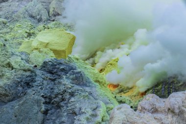 Ijen Dağı 'nın içinde sarı sülfür ve Doğu Java, Endonezya' da aktif volkanla kaplı bir yamaç. Volkanik bacalardan yükselen kalın dumanlar.