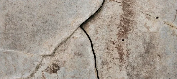 Yıpranmış beton duvarlar yüzeylerinde doğal çatlaklar ve kusurlar gösteriyor..
