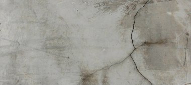 Yıpranmış beton duvarlar yüzeylerinde doğal çatlaklar ve kusurlar gösteriyor..