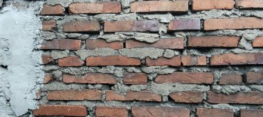 Kaba desenli tuğla duvar ve tuğlaların arasında havan topu görünüyor..