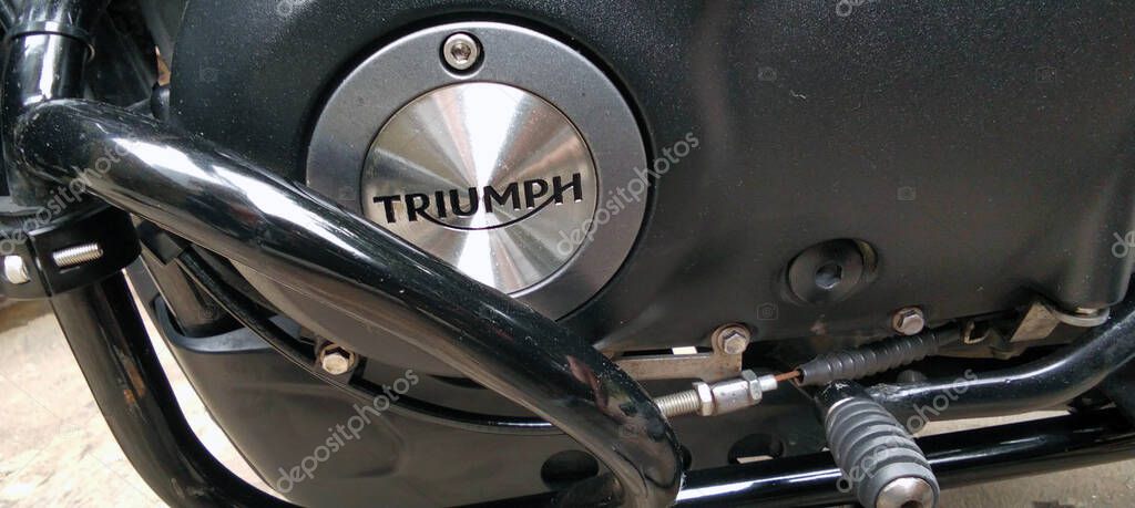 A Triumph motorcycle engine featuring the metal Triumph logo on the crankcase cover.