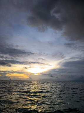 Sakin denizin üzerinde altın bir günbatımının yansıması