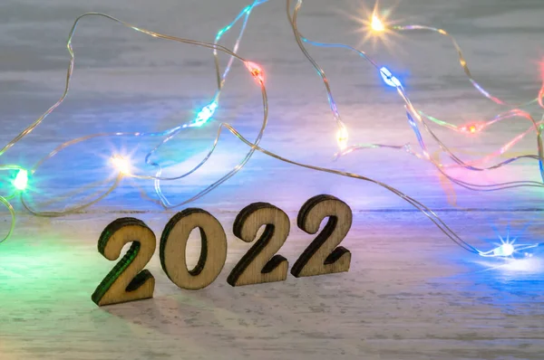 Wooden figures 2022 and garland. Banner 2022. Figures 2022 on beige background. New Year\'s calendar.