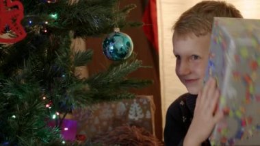 Mutlu çocuk seyir için yeni yıl ağacın altında sunar