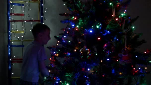クリスマスの靴下に忍び寄るパジャマの少年 — ストック動画