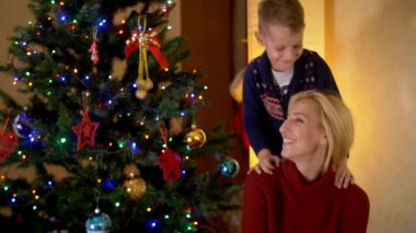 Bir Noel ağacı altında oğluyla mutlu sarışın anne.