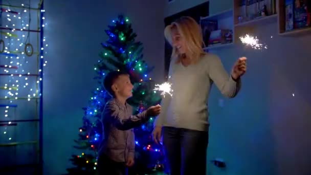 Feliz madre y su hijo mirando los destellos del fuego de Bengala . — Vídeos de Stock