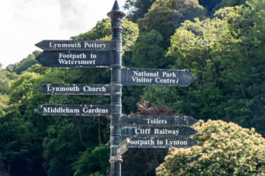 Lynmouth Pottery, Watersmeet, Ulusal Park Ziyaretçi Merkezi, Lynmouth Kilisesi ve bir uçurum demiryolu gibi yerel manzaraları gösteren, gür ağaçlar arasında yıpranmış bir metal tabela bulunmaktadır. Bol seyahat cazibesi ve antika cazibesi.