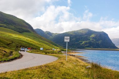 Slow-driving car on single wavy, serpentine road in NC500, Scotland