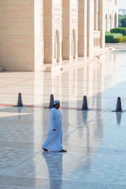 Muscat, Umman - 31 Aralık 2023: Umman, Umman 'daki Sultan Qaboos Büyük Camii boyunca yürüyen Umman Arap.