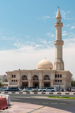Ali ibn Abi Talib Camii, Al Wakrah, Katar: 21 Mart 2025. Büyük kubbeli ve ince minareli sakin bir Ali ibn Talib Camii işlek bir caddenin yanında yükseliyor. Yayalar geçerken arabalar kaldırım kenarına diziliyor. Kültürel mimari, seyahat, inanç...