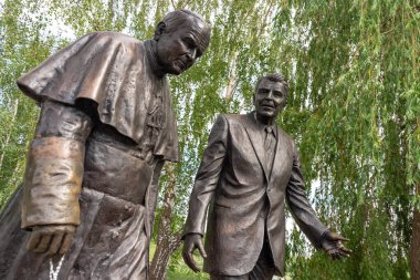 Gdansk, Polonya: 3 Haziran 2024: ABD Başkanı Ronald Reagan ve Papa 2. John Paul 'un heykellerinin yer aldığı iki gerçek boyutta bronz heykel, dostluk, haysiyet ve kamu sanatı arasında barış dolu bir parkta oturup dururlar..
