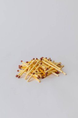 Ahşap kibritlerin stüdyo fotoğrafı temiz beyaz arka planda bir yığın içinde düzenlenmiş.