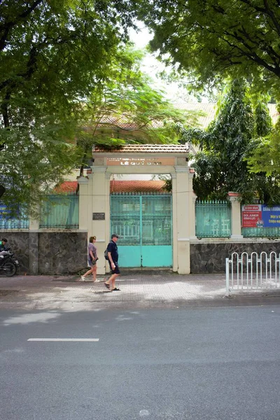 Ho Chi Minh City, Vietnam 'daki Le Quy Don Lisesi' nin 9 Kasım 2025 tarihli fotoğrafı: Demirhindi yapraklarının altındaki antik okul kapısı