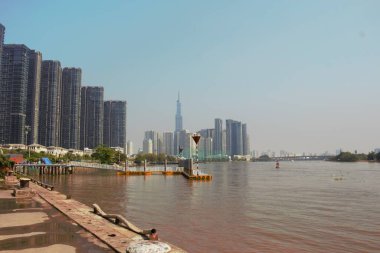 8 Ocak 2026 'da Vietnam' ın Ho Chi Minh şehrindeki Saigon Marina IFC binasındaki Landmark 81 kulesinin fotoğrafı: Saigon nehrinin oldukça yüzeyi ve mesafe olarak Landmark 81 kulesi