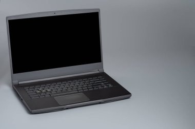 Gri arkaplanda boş ekranlı dizüstü bilgisayar aç.