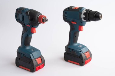 Beyaz arka planda kırmızı ve mavi aksanlı kablosuz matkap ve çarpma anahtarı..