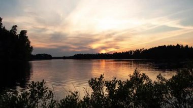 Orman Gölü üzerinde sakin bir yaz akşamı. Gün batımının yumuşak renkleri suya yansıyor. Barışçıl doğayı, dinginliği ve sakin İskandinav manzarasını gösteren zaman çizelgesi