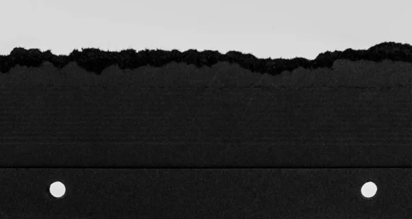 Sert Kenarlı Siyah Yırtık Kağıt ve Açık Arkaplanda Yumruk Delikleri