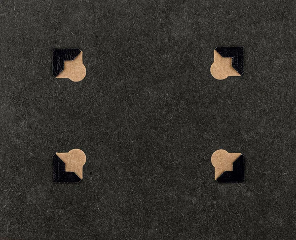 Eski bir albümün dört klasik fotoğraf köşesinden oluşan minimalist bir kompozisyon. Çerçevenin köşelerinde, koyu renkli kağıt bir arka planla düzenlenmiş. Arşiv, hatıra defteri.