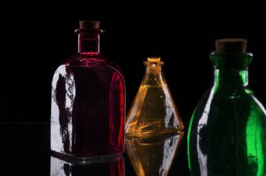 Üç renkli dekoratif şişenin tıpası siyah arka planda..