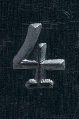 Gri ve zemin çelikten bir plakaya işlenmiş 4 numaranın detaylı görüntüsü. 