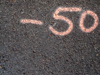 Pembe ile asfalta yazılmış eksi 50 sayısının üst görünümü.