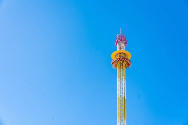 Bir lunaparkta ya da Oktoberfest panayırında parlak mavi bir gökyüzüne karşı renkli bir kule gezisi uzun sürer. Canlı yapı, karnaval çekimlerinin heyecanını, heyecanını ve neşesini yakalıyor. Boş zamanları, seyahatleri ve eğlenceyi resmetmek için mükemmel.