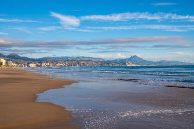 Sahil sahnesi sakin, sakin kıyı şeridi şehir ışıklarını yansıtan sakin deniz kenarı renkli gökyüzü ve parıldayan yansımalarla, şehir manzaralı huzurlu sahil manzarası ve yumuşak, ışıltılı havuzlar.
