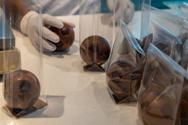 Paketleme teknisyenleri çikolatalı trüf mantarları eldivenli eller trüf mantarları şeffaf selofan torbalara yerleştiriyor.