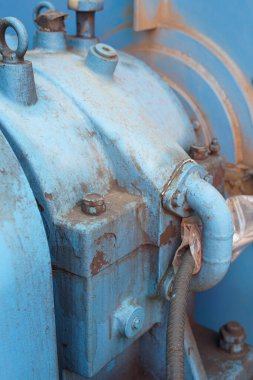 Bu yakın çekim, sıkıntılı endüstriyel makinelerin karmaşık detaylarını yakalıyor. Paslanmış ve yıpranmış metalik yüzey, endüstriyel dayanıklılığın altını çizerek bir yaş ve kullanım hikayesi anlatıyor.