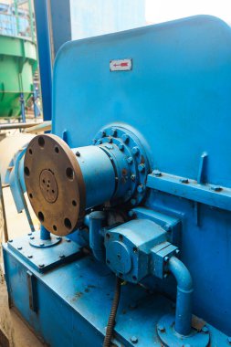 Bu yakın plan fotoğraf, sağlam yapısını ve gelişmiş mekanik tasarımını vurgulayan, ağır iş sanayi makinelerinin karmaşık detaylarını sergiliyor. Ekipmanların mavi tonu vurguluyor