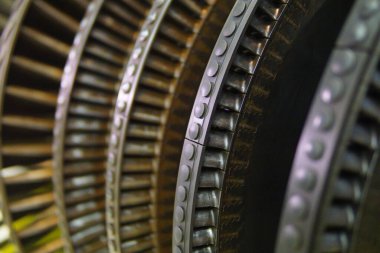 Endüstriyel türbin pervanelerinin hassasiyetini ve karmaşıklığını gösteren detaylı bir yakın çekim, enerji üretiminin arkasındaki teknolojiyi ve karmaşık mühendisliği vurguluyor..