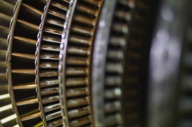 Karmaşık bıçaklarını gösteren bir türbin pervanesinin detaylı yakın çekimi. Bir enerji santralindeki enerji üretim uygulamalarında kullanılan hassas mühendislik ve endüstriyel mekanik tasarımı resmeder.