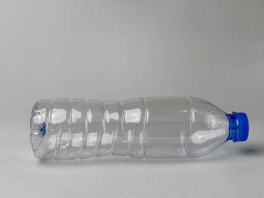 Tarafsız bir arka planda mavi kapaklı boş plastik şişe. Geri dönüşüm kavramları, sürdürülebilir ambalaj ve sorumlu atık yönetimi için ideal.