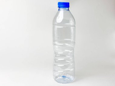 Temiz bir plastik su şişesinin atölye çekimi. Mavi kapaklı ve saf su ve sağlık ve ferahlatıcı temaları sembolize eden el değmemiş beyaz bir arka plan.