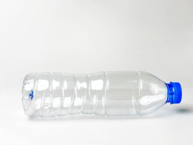 Geri dönüşümün önemini ve korunma sürdürülebilirliğini gösteren mavi kapaklı boş saydam geri dönüşümlü PET şişesinin stüdyo görüntüsü.